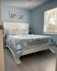 a bedroom with a bed in a blue room at Manasota Key Cottage B in Englewood