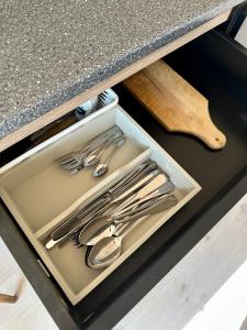 a drawer in a counter with utensils in it at LODGE, een super knus tiny house, nabij vaarwater en haven! in Belt-Schutsloot