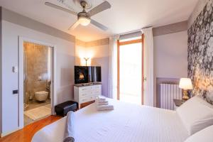 um quarto com uma cama branca e uma casa de banho em B&B Il Tiglio em Porto SantʼElpidio