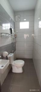 La salle de bains blanche est pourvue de toilettes et d'un lavabo. dans l'établissement Comfy room in Gunung Ledang, 