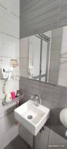 La salle de bains est pourvue d'un lavabo et d'un miroir. dans l'établissement Comfy room in Gunung Ledang, 