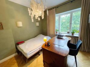 Schlafzimmer mit einem Schreibtisch, einem Bett, einem Tisch und einem Stuhl in der Unterkunft Spacious apartment in city center in Tallinn