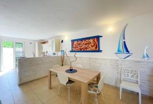 a dining room with a wooden table and chairs at Leuca Casa del Mare in centro in Leuca
