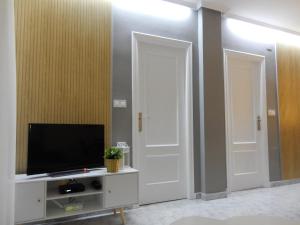 salon z dwoma białymi drzwiami i telewizorem w obiekcie Apartment Amelia w mieście La Mata