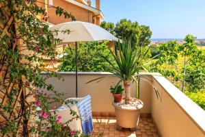 un balcon avec un parasol et des plantes en pot dans l'établissement B&B Il Tiglio, à Porto SantʼElpidio