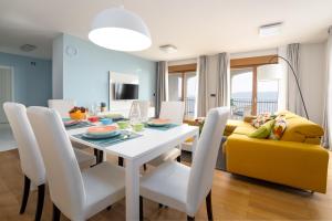 a dining room with a table and a yellow couch at Großzügiges Appartement direkt am Meer mit eigenem Pool - Povile Suites in Novi Vinodolski
