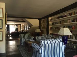 una sala de estar con 2 sofás y estanterías con libros en Casa rural con piscina privada, en Casar de Palomero