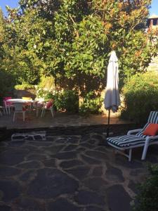 une terrasse avec un parasol, des chaises et une table dans l'établissement Casa rural con piscina privada, à Casar de Palomero