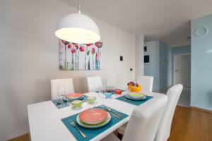 un comedor blanco con una mesa blanca y sillas blancas en Großzügiges Appartement direkt am Meer mit eigenem Pool - Povile Suites, en Novi Vinodolski