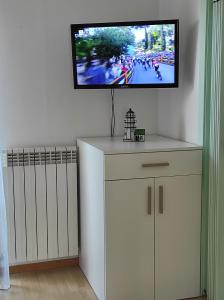 a room with a tv on a wall with white cabinets at Attico solare fronte mare in Porto Recanati