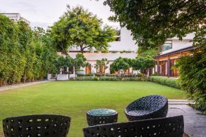 un jardín con sillas y un edificio en The Manor - New Delhi, en Nueva Delhi