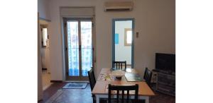a dining room with a table and a television at CASA SIRENETTA-Little Mermaid House in Lentini +2 photos