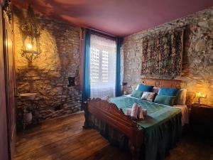 a bedroom with a bed and a stone wall at Il Pievano B&B in Campiglia Marittima
