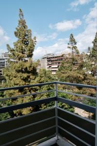 a balcony with a view of trees and buildings at SynPiraeus Apartments & Studios in Piraeus