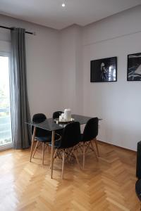 a dining room with a black table and chairs at SynPiraeus Apartments & Studios in Piraeus