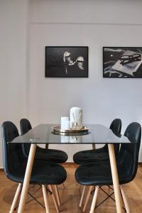 comedor con mesa de cristal y sillas negras en SynPiraeus Apartments & Studios, en Pireo