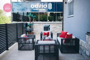a patio with black wicker chairs and red pillows at Adria centar Koćuša in Ljubuški