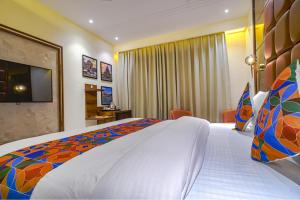 a hotel room with a large bed and a television at FabHotel Benchmark in Indore