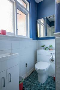 a blue bathroom with a toilet and a sink at Winterstoke View-Family&Dog Friendly Beach Retreat in Ramsgate