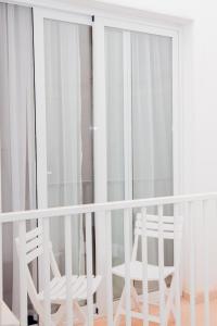 two white chairs sitting on a balcony at Giorgio Boutique Hotel in Sliema