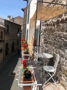 un patio con sillas, mesas y flores en un edificio en Antica residenza La Rocca en Montefiascone