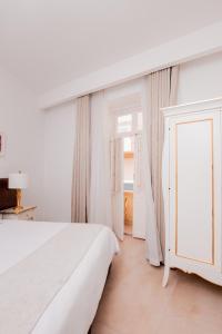 a white bedroom with a bed and a window at Giorgio Boutique Hotel in Sliema
