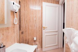 a bathroom with a white sink and a white door at Giorgio Boutique Hotel in Sliema