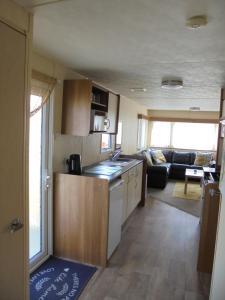a kitchen and living room of a caravan at Highfield and Haven : Elegance:- 4 Berth Central Heated in Lincolnshire