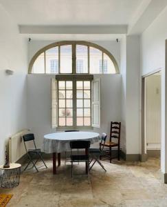 una camera con tavolo, sedie e finestra di Appartement dans belle résidence Semuroise a Semur-en-Auxois