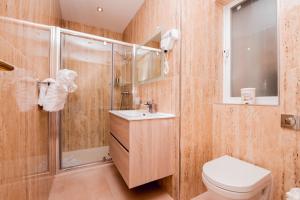a bathroom with a shower and a toilet and a sink at Giorgio Boutique Hotel in Sliema