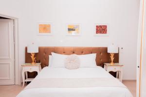 a bedroom with a large white bed with two end tables at Giorgio Boutique Hotel in Sliema