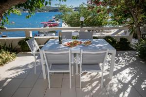 un tavolo e sedie su un patio con vista sull'acqua di Beachfront Apartment with 1 bedroom and terrace a Supetarska Draga