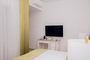 a hotel room with a bed and a flat screen tv at Giorgio Boutique Hotel in Sliema