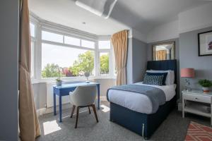 a bedroom with a bed and a desk and a window at Winterstoke View-Family&Dog Friendly Beach Retreat in Ramsgate