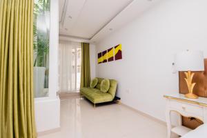 a living room with a green chair and a window at Giorgio Boutique Hotel in Sliema