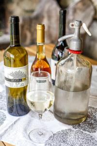 two bottles of wine and a glass of white wine at Myrtus Pince és Vendégház in Tarcal