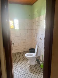 a bathroom with a toilet and a tiled floor at A&G Guest House in Kumba