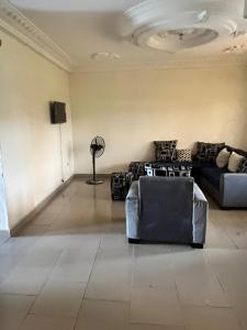 ein Wohnzimmer mit 2 Sofas und einem TV in der Unterkunft A&G Guest House in Kumba