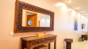 ein Badezimmer mit einem Spiegel und einem Holztisch in der Unterkunft Ruby and Pearl by Flair Apartments in Lagos