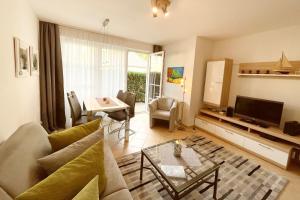 a living room with a couch and a table and a television at Maria Gabriele Karlstrasse 6b Ferienwohnung 05 in Stubbenfelde