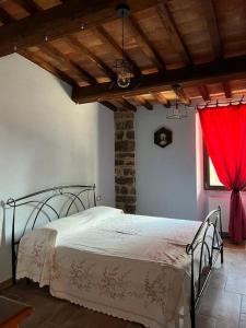 1 dormitorio con 1 cama con cortina roja en Agriturismo Botri dei Lumachi, 