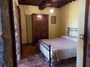 1 dormitorio con 1 cama y puerta de madera en Agriturismo Botri dei Lumachi, 