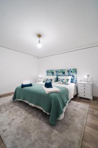 una camera da letto con un grande letto con una coperta verde di Casa Milita a São João da Pesqueira