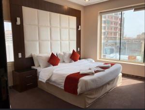 a bedroom with a large bed with a large window at Dar Hotel Suites in Jeddah