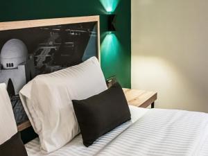 卡拉奇LOKAL Rooms x Shahrah-e-Faisal (Nursery)的一间卧室配有一张带黑白枕头的床