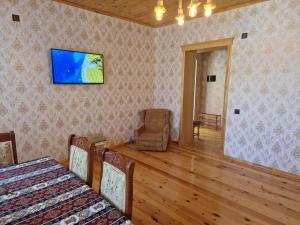 ein Wohnzimmer mit 2 Betten und einem TV an der Wand in der Unterkunft Mountain Resort House in Qəbələ