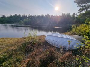 un barco sentado en la orilla de un lago en Solhytta Fantastisk beliggenhet! Hytte til leie på Skrim!, en Kongsberg