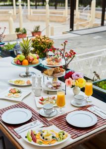 uma mesa com pratos de comida e bebidas em Grande Albergo Delle Rose in Ilha de Rhodes
