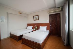 sypialnia z 2 łóżkami i drzwiami z kwiatami w obiekcie Van Ha Hotel w Ho Chi Minh