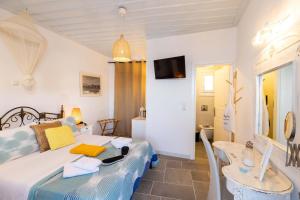 プラティスヤロス・シフノスにあるKohylia Beach Guest Houseのベッドルーム(ベッド1台、テーブル、テレビ付)